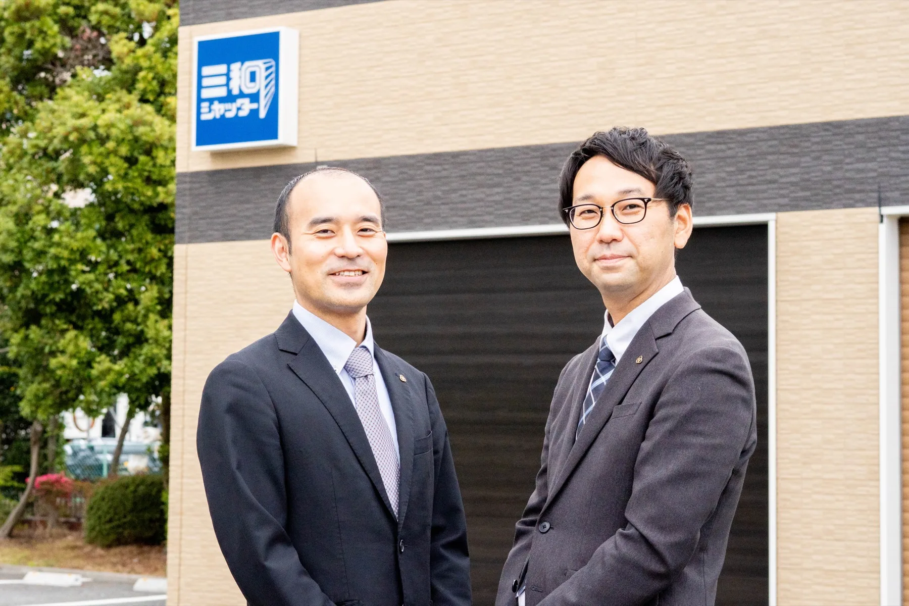 三和シヤッター工業株式会社　品質保証部　カスタマーセンター　一般修理受付課　稲生 竜氏（左）　渡邉 聡氏（右）
